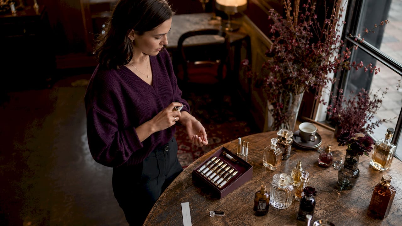 Woman sampling artisanal fragrances at home Image