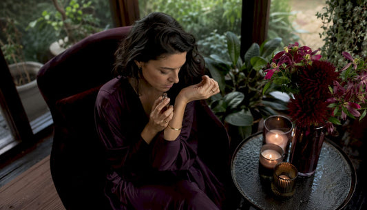 Une femme hume les notes d’un parfum, le visage marqué par une intense concentration.