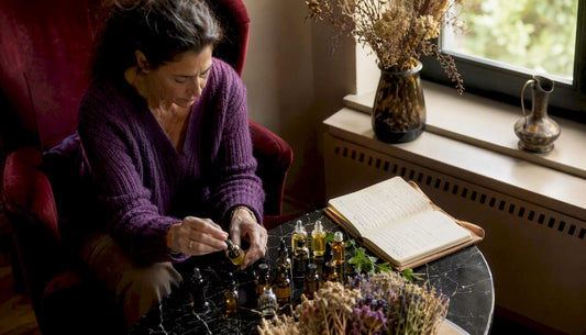 Une femme en train de préparer ses propres mélanges d’huiles essentielles pour une séance d’aromathérapie.