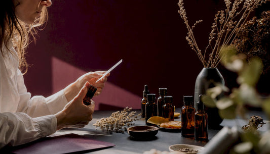 Detalle de frascos de perfume y plantas aromáticas sobre una mesa