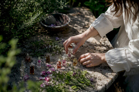 Hands arranging fragrance vials on wooden table