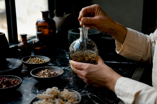 Manos mezclando esencias naturales para crear perfumes