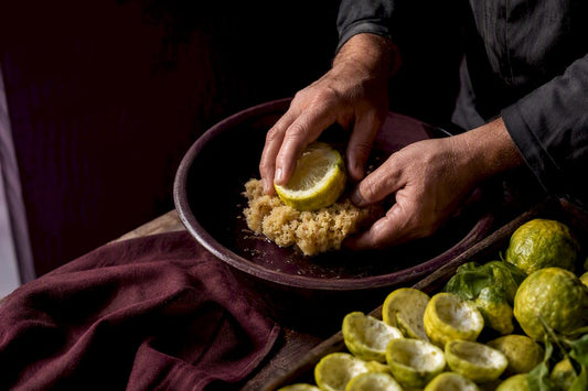 Hands extracting bergamot oil by spugnatura