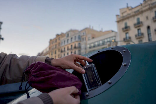 Manos reciclando un frasco de vidrio vacío