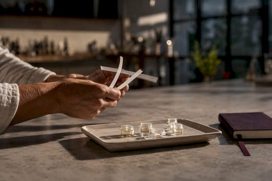 Manos comparando muestras de perfumes artesanales