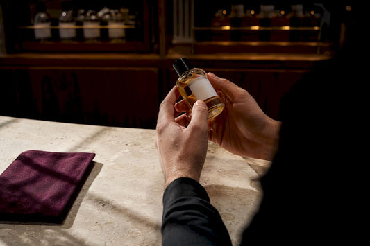 Manos inspeccionando un frasco de perfume artesanal