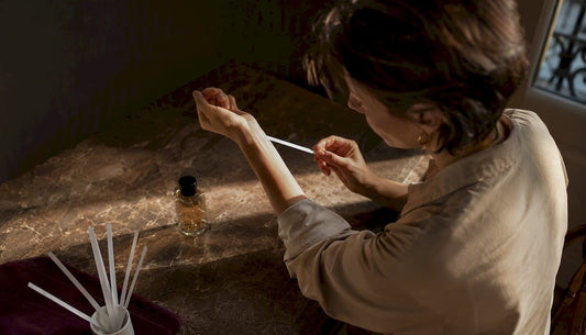 Persona aplicándose una fragancia natural en la muñeca