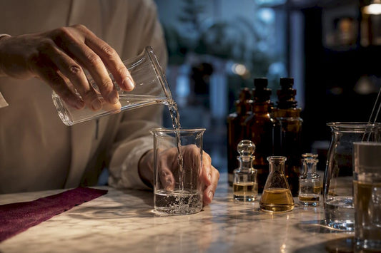 Hands measuring ethanol for perfume formulation